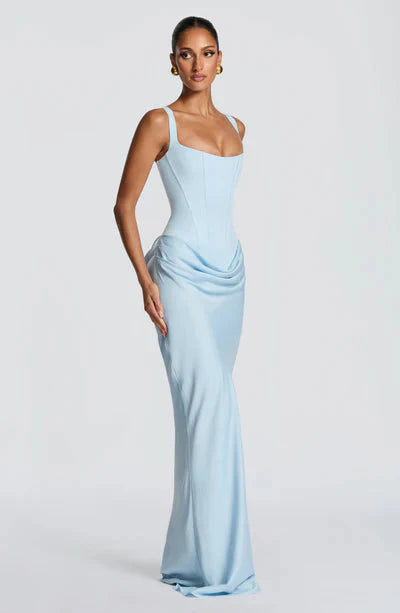 Side profile of a light blue Celeste corset maxi dress, highlighting the fitted bodice and flowing skirt.