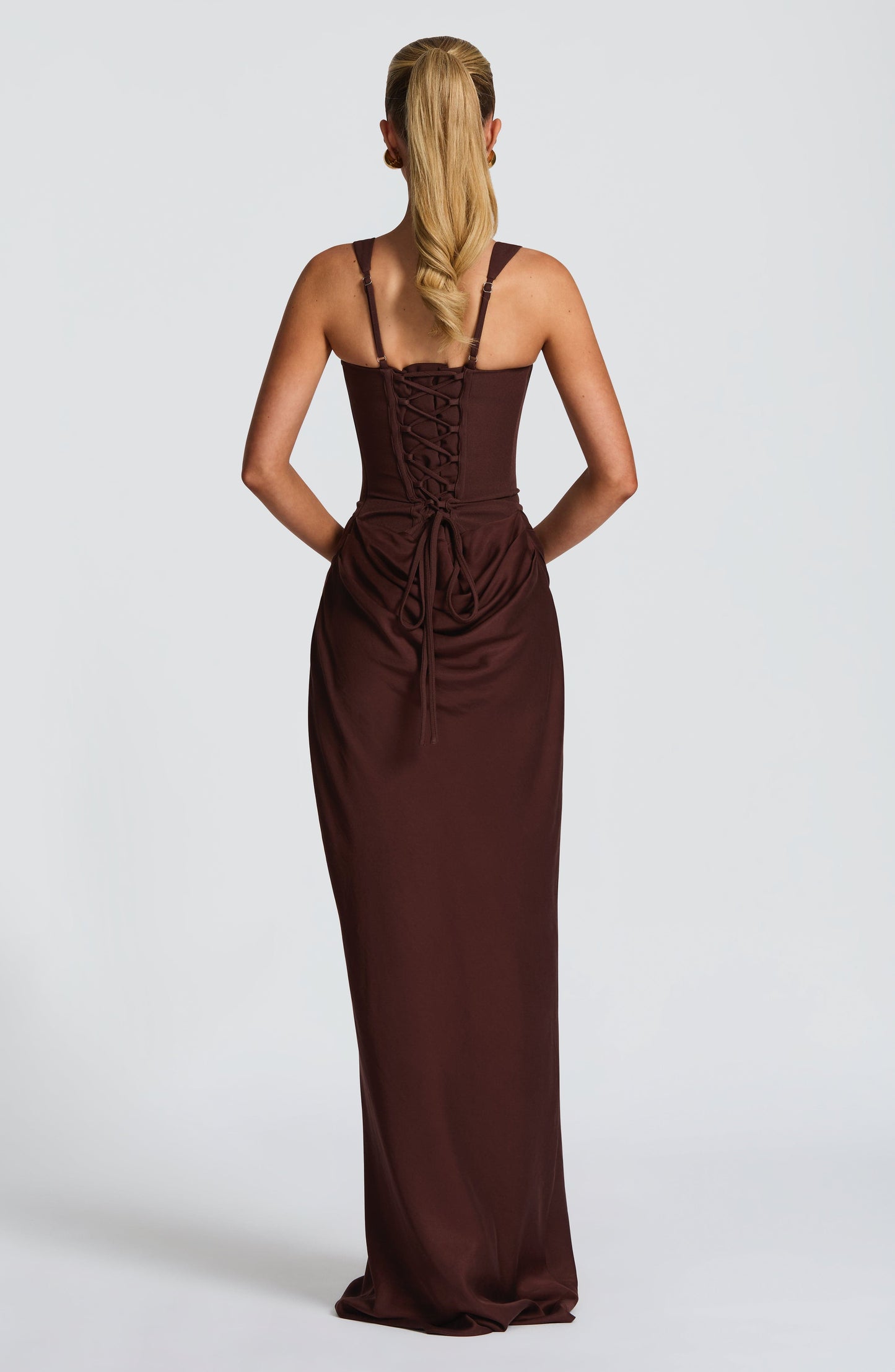 Back view of the chocolate brown Celeste Corset Maxi Dress, featuring a lace-up corset detail and long skirt.