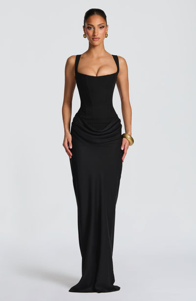 Full-length front view of a black Celeste Corset Maxi Dress, with a square neckline and draped waist detail.