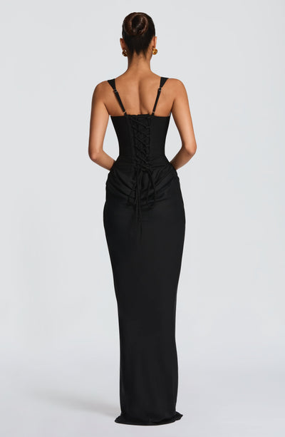 Back view of the black Celeste Corset Maxi Dress, showing the lace-up corset back and floor-length skirt.