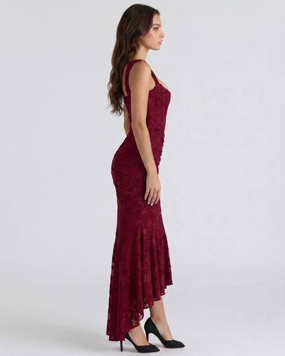 Side view of burgundy corset midi dress with fitted lace bodice, ruched skirt and high-low hem