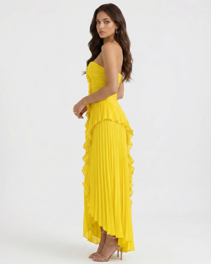 Side view yellow ruffle maxi dress showing fitted waist, tiered ruffle trim and pleated high-low hem