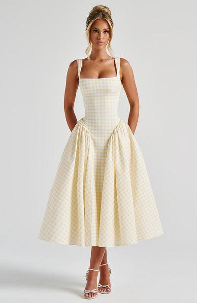 Front view of a light yellow gingham corset midi dress with a square neckline and a voluminous skirt, suitable as a dress suit.