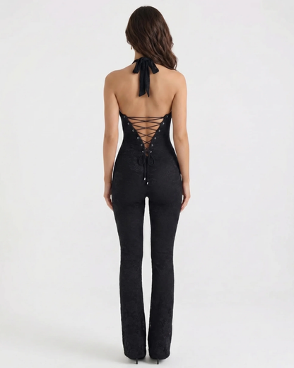 Back view black corset jumpsuit with halter tie neck and lace-up corset back, flared pants