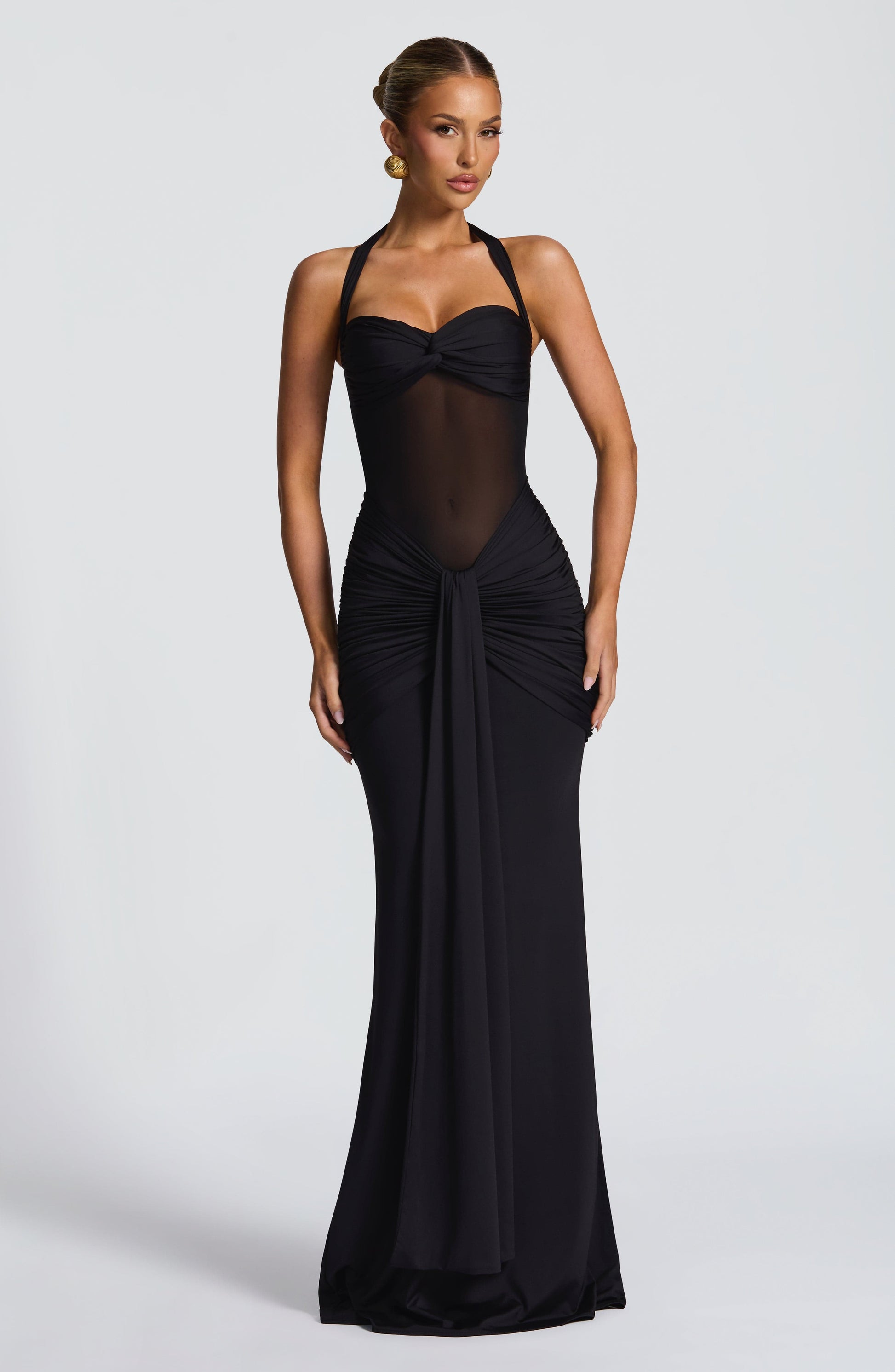 Full-length black Jayleen Ruched Maxi Dress with sheer mesh midriff and halter neckline, front view.