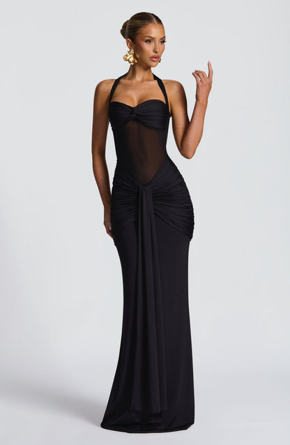 Black halter neck maxi dress featuring a ruched skirt and sheer bodice, showcasing elegant design.