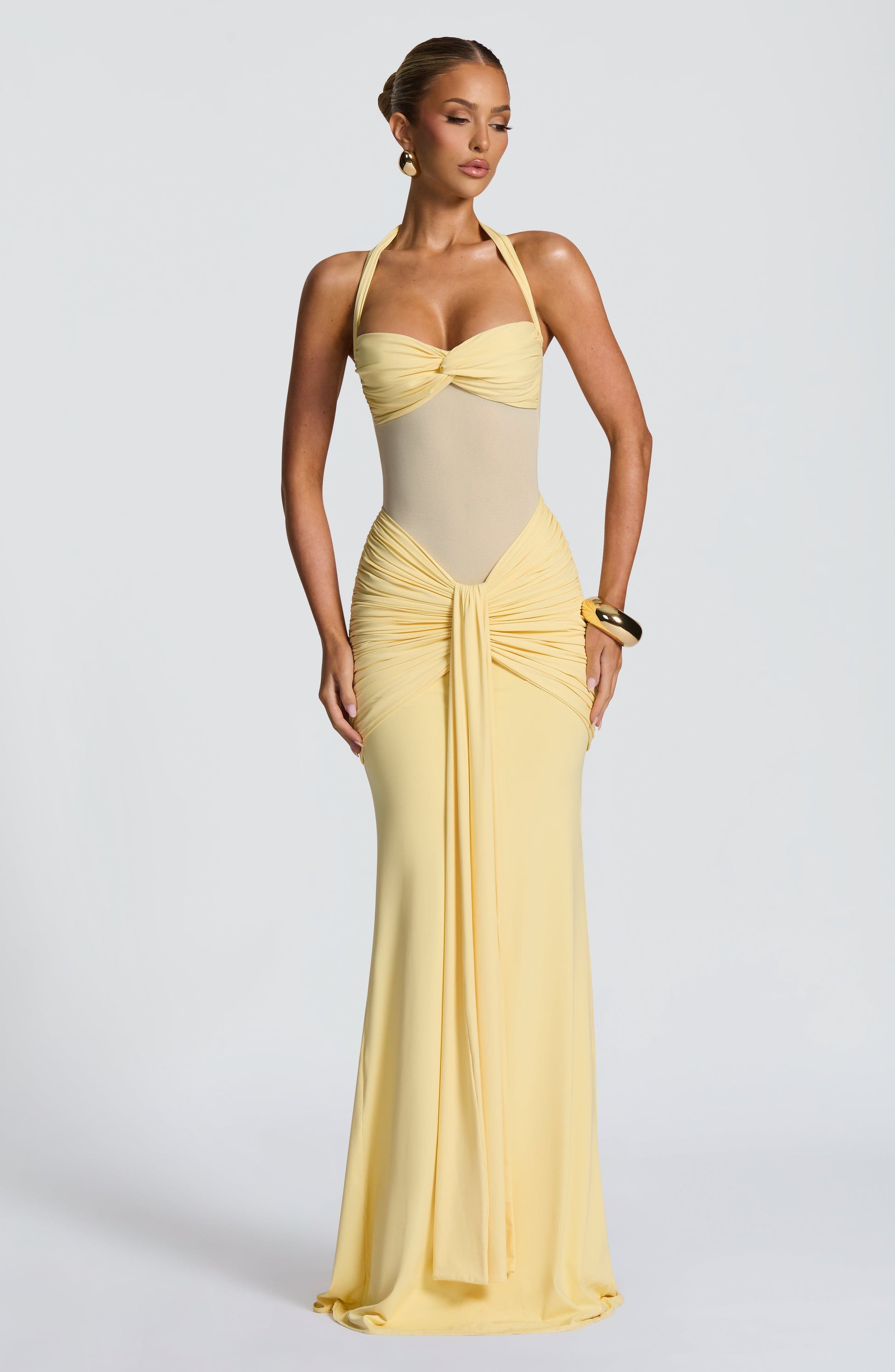 Front view of a pastel yellow Jayleen Ruched Maxi Dress, showcasing the ruched waist and flowing skirt.