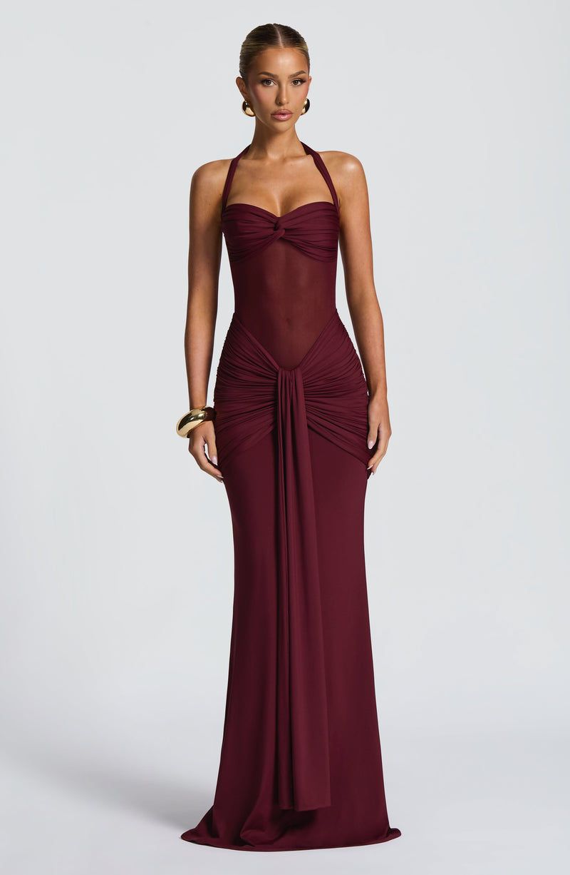 Full length view of a deep red Jayleen Ruched Maxi Dress with halter neckline and front knot detail.