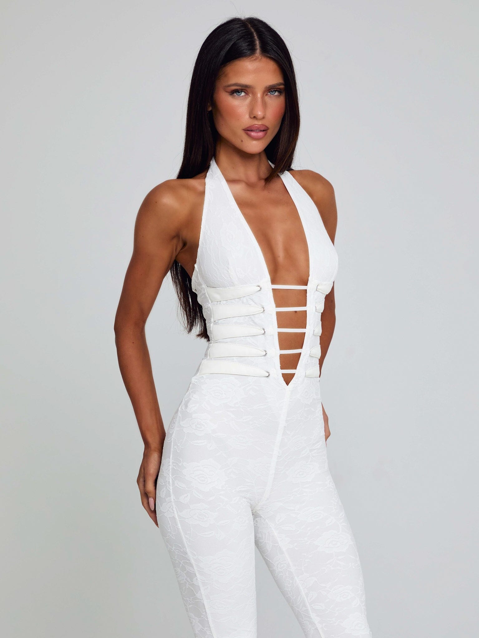 Front view of a white Kenzie Halter Jumpsuit, showcasing a deep V-neck and white strap detailing on the bodice.