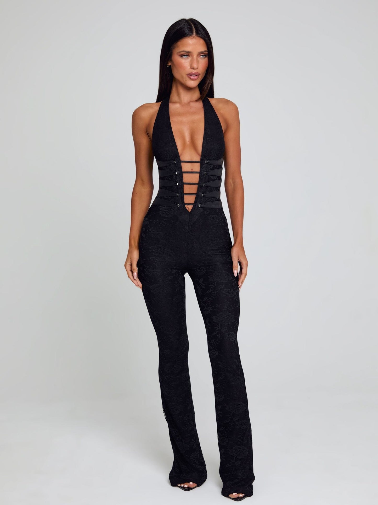 Full view of the black Kenzie halter jumpsuit, showcasing its deep V-neck, structured corset waist, and flared pant legs.