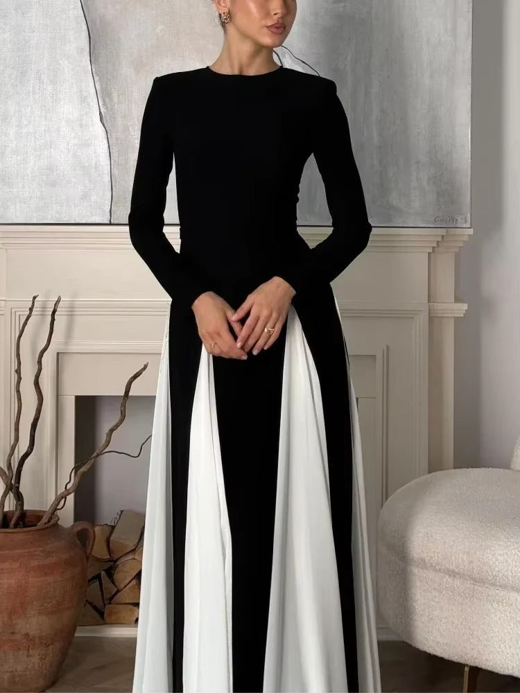 Close-up of a long sleeve black dress with white paneled skirt details, suitable for a wedding dress.