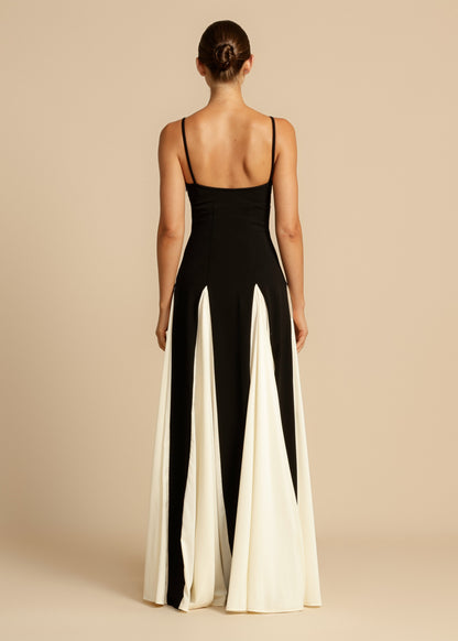 Rear view of a black and white paneled maxi dress, showcasing the full skirt and thin shoulder straps.