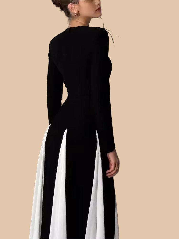 Side profile of a long sleeve black dress with white paneled skirt, elegant and modest design.