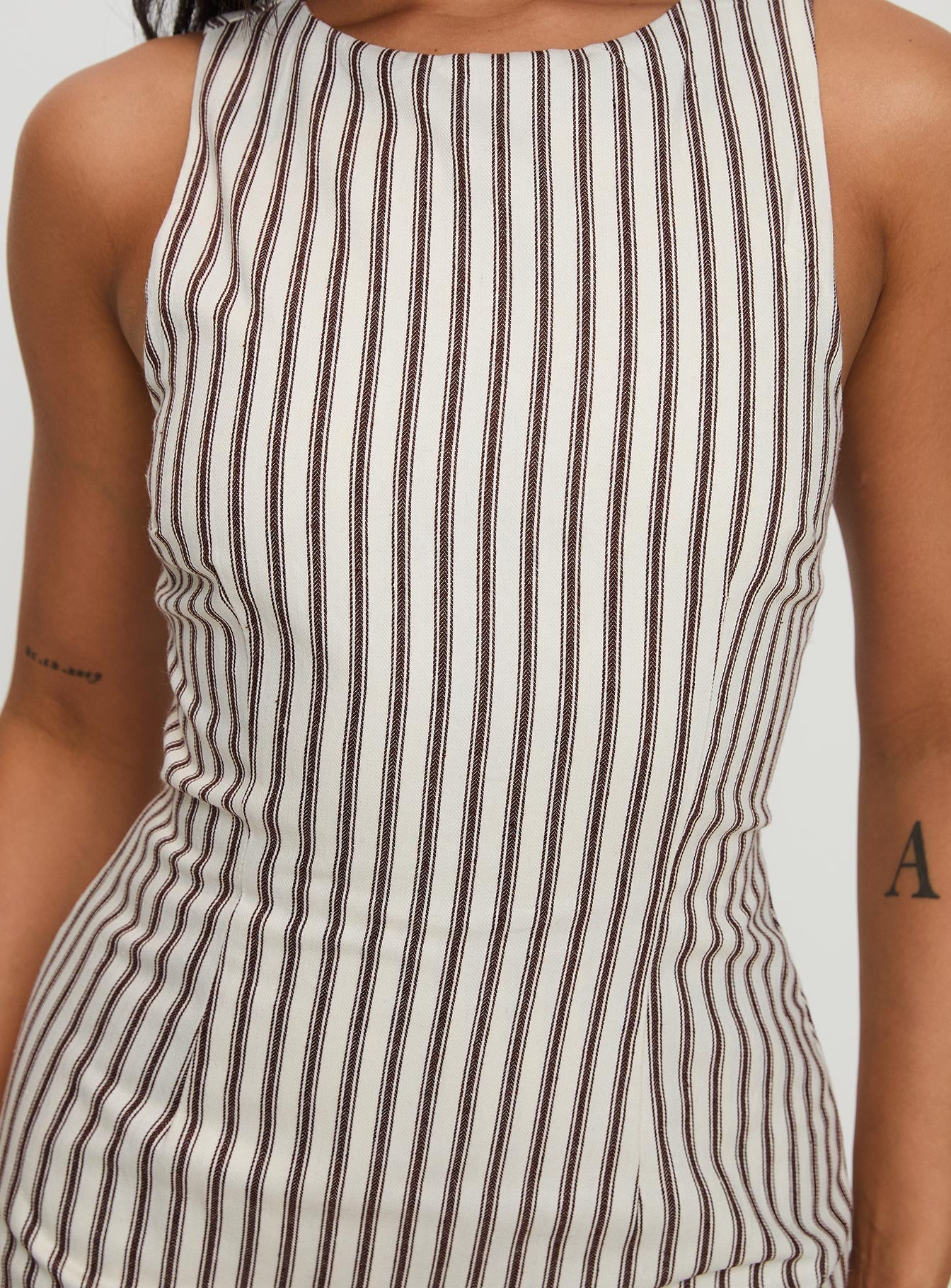 Close-up of the bodice of a sleeveless Lauren striped mini dress, showing brown vertical stripes.