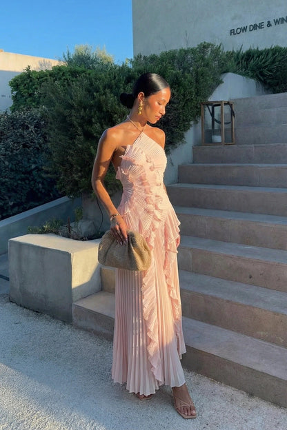 Woman in the pink Millie Ruffle Midi Dress walking down stairs, highlighting the flowy pleated skirt and ruffles.