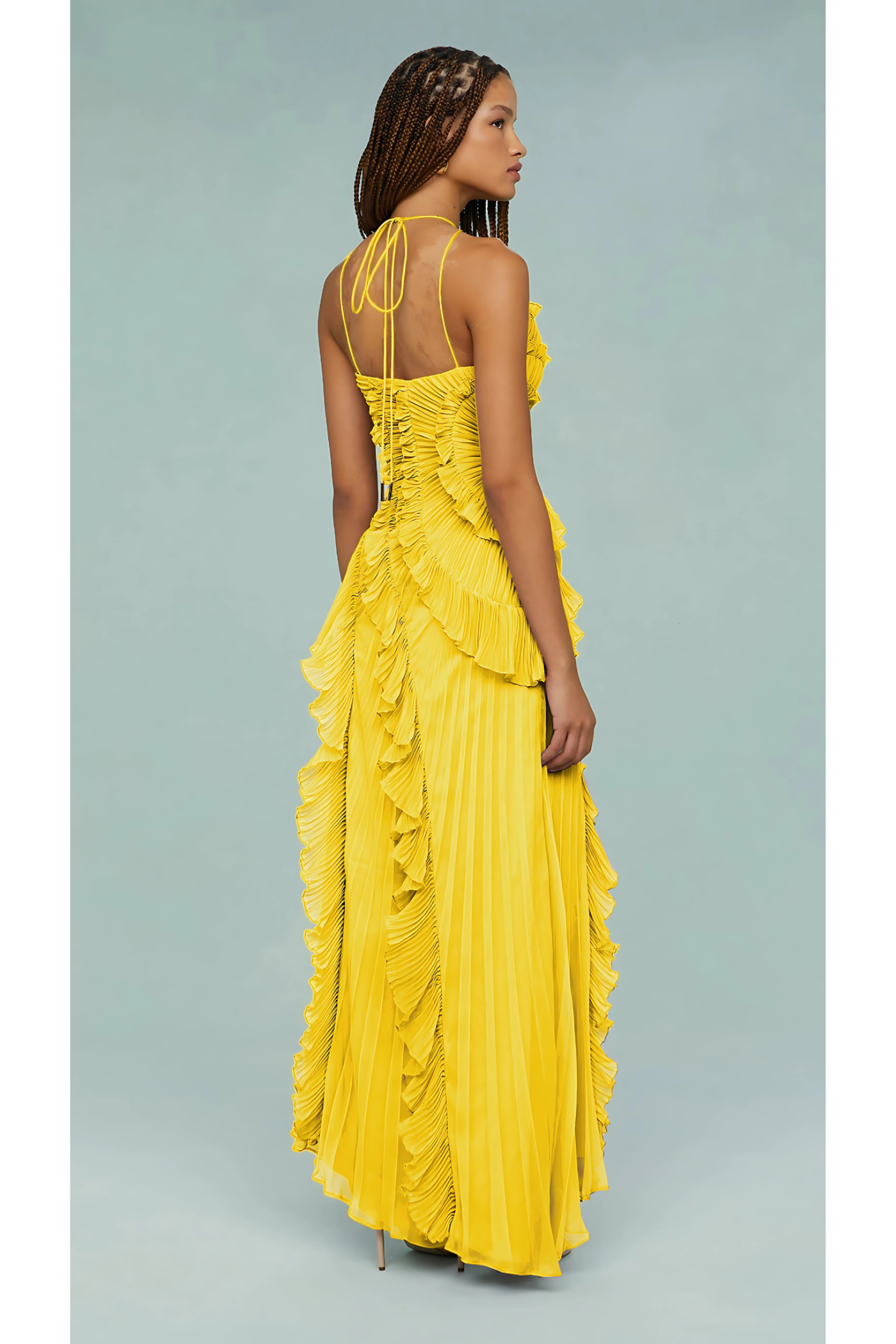 Rear view of a yellow Millie Ruffle Midi Dress, showing the crisscross back straps, pleated skirt, and ruffle details.