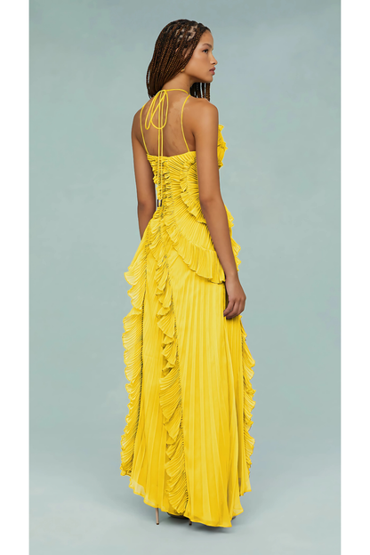 Rear view of a yellow Millie Ruffle Midi Dress, showing the crisscross back straps, pleated skirt, and ruffle details.