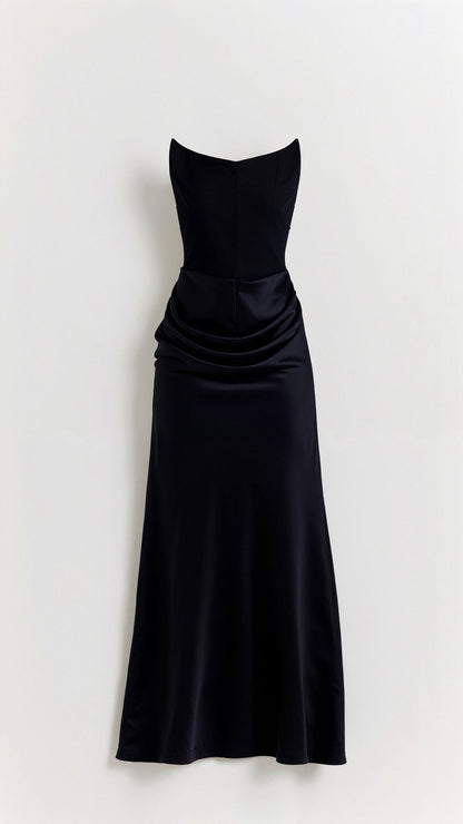 Black strapless maxi dress with a structured bodice and elegant draped waist detail, flowing into a sleek skirt.