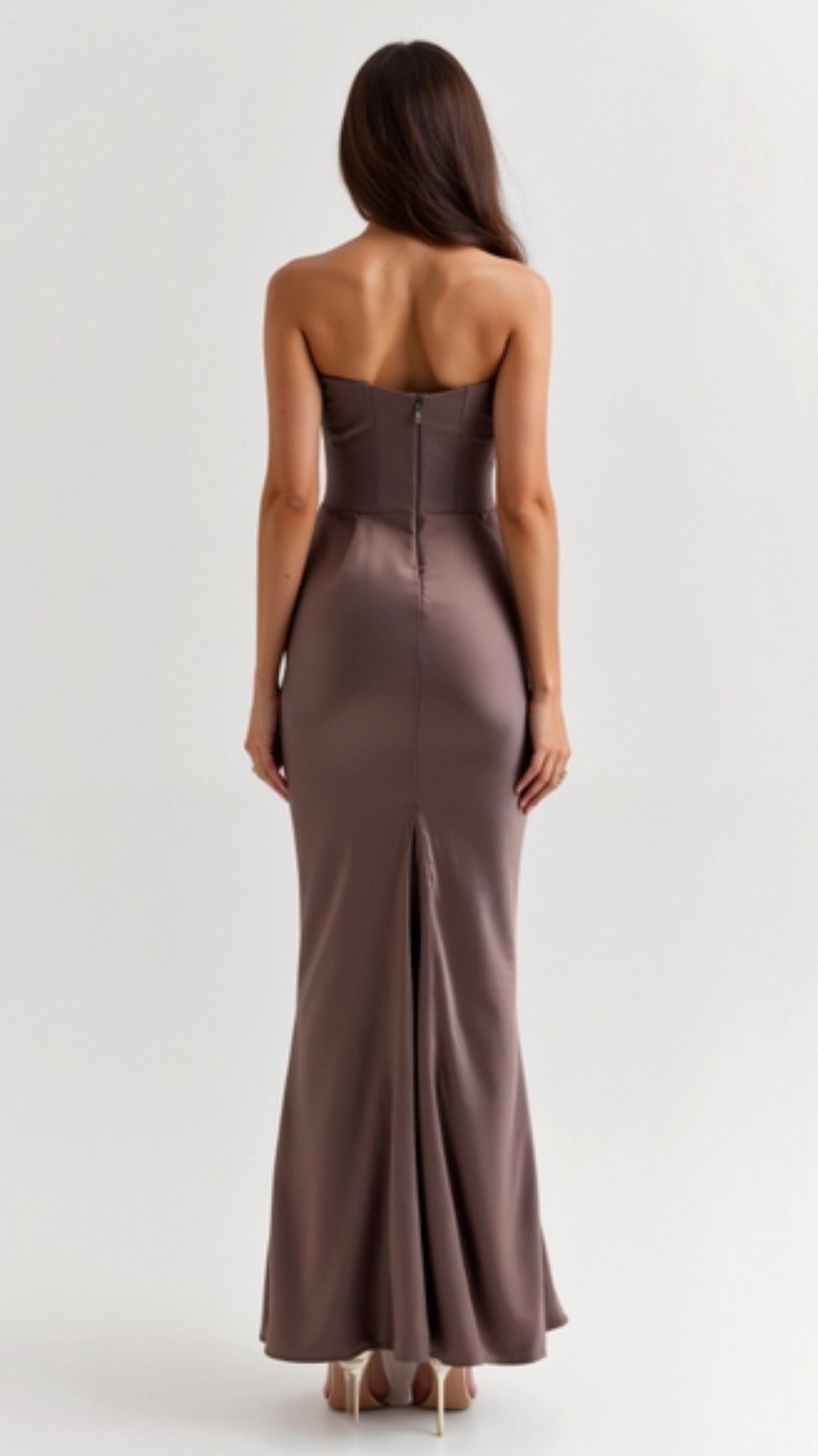 Back view of a woman wearing a mocha brown strapless maxi dress with a hidden zipper and subtle back slit, showcasing the fitted silhouette.