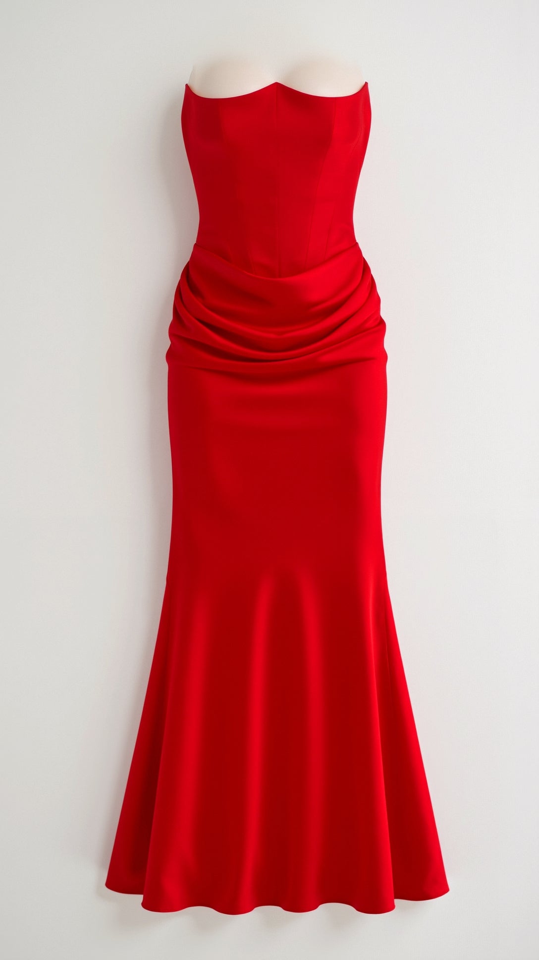 Bright red strapless maxi dress with a fitted bustier top and artfully draped fabric around the midsection, creating a flattering shape.