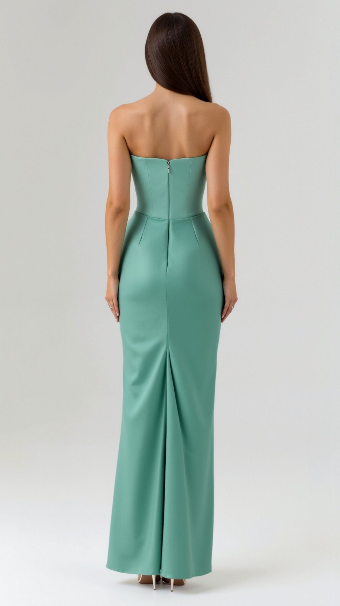 Back view of a woman wearing a seafoam green strapless maxi dress, showing the elegant back zipper and a subtle kick pleat.