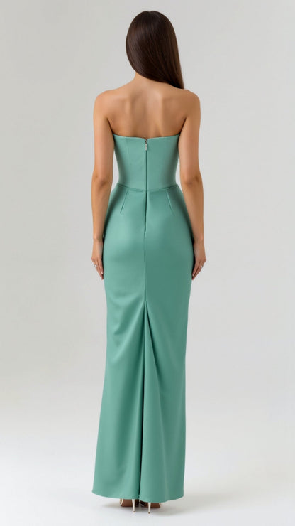 Back view of a woman wearing a seafoam green strapless maxi dress, showing the elegant back zipper and a subtle kick pleat.