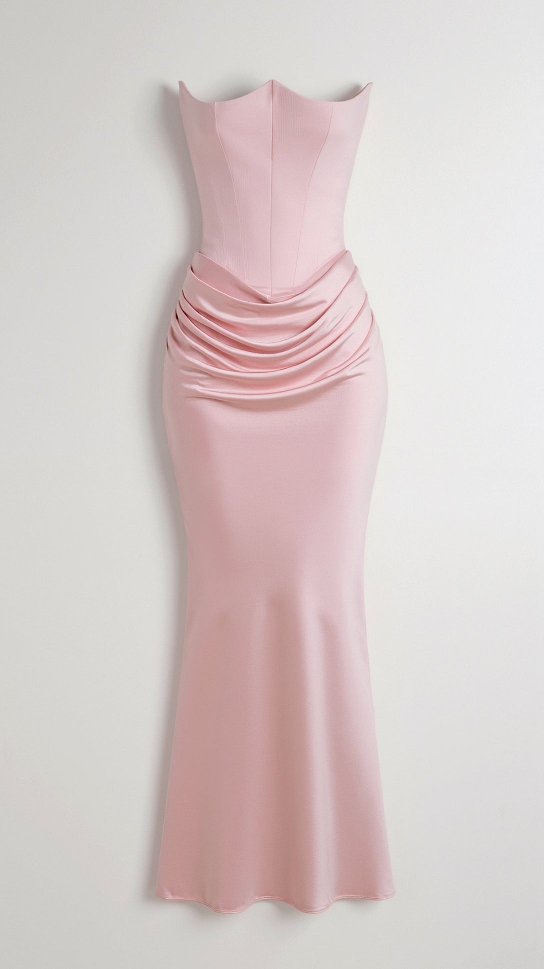 Light pink strapless maxi dress with a tailored bodice and sophisticated draped ruching across the mid-body, perfect for a formal event.