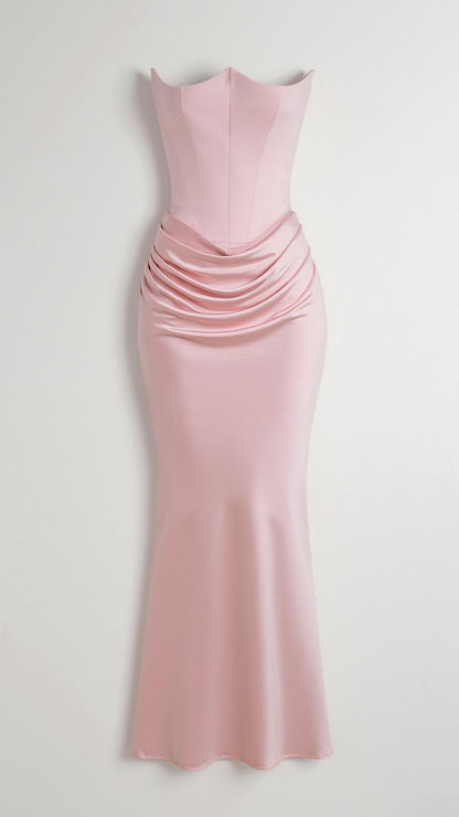 Light pink strapless maxi dress with a tailored bodice and sophisticated draped ruching across the mid-body, perfect for a formal event.