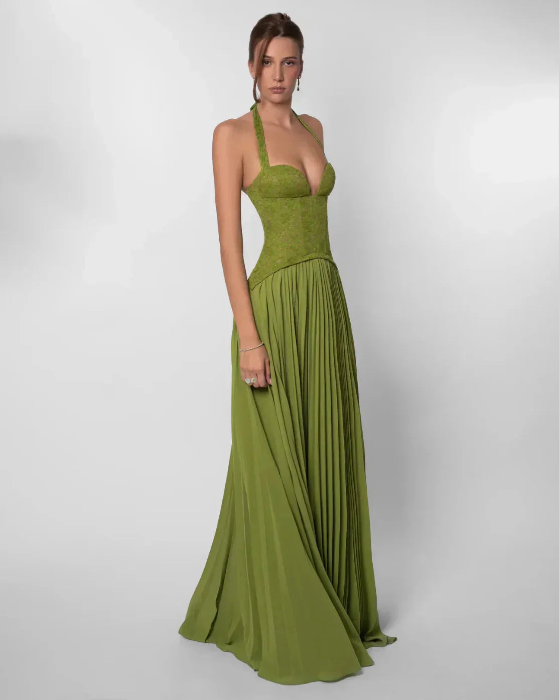 Side profile of green lace maxi dress with full pleated skirt and halter neck for women.