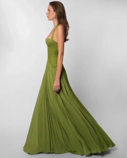 Model walking in green lace maxi dress with flowing pleated skirt and halter top for women.
